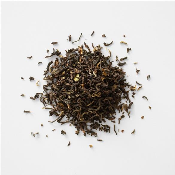 A pile of Darjeeling Second Flush Lingia EX3 tea on a white background by Rishi Tea & Botanicals.