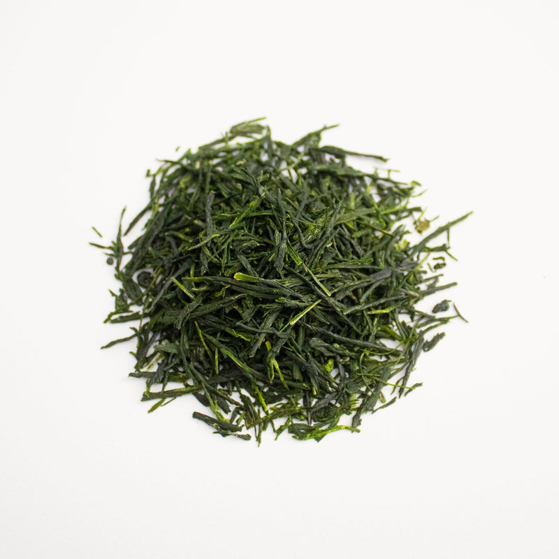 A pile of Gyokuro Gokou green tea from Rishi Tea & Botanicals on a white surface.