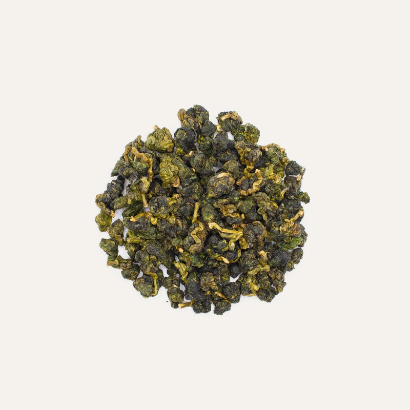 A pile of Li Shan Oolong Winter Harvest from cool winter climate regions, on a white background, by Rishi Tea & Botanicals.