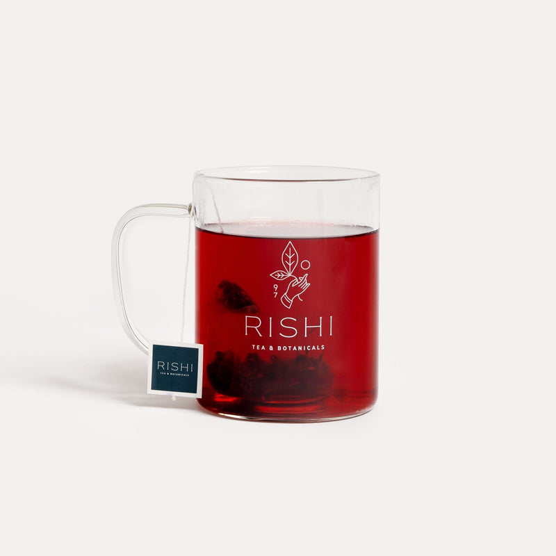 A cup of tea with a Rishi Tea & Botanicals Glass Simple Mug and a tea bag in it.