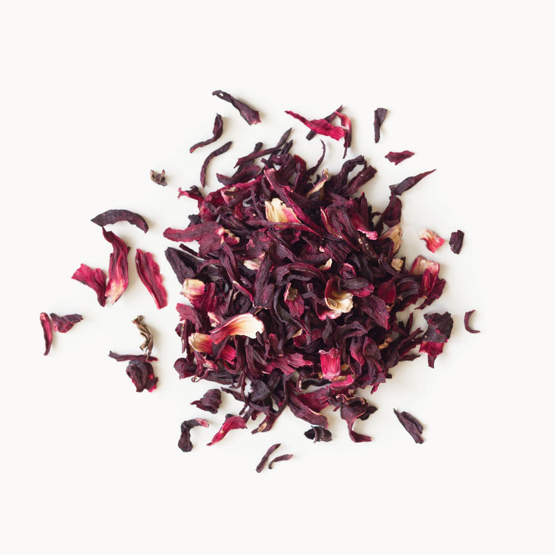 A pile of dried hibiscus petals on a white background, from Rishi Tea & Botanicals.