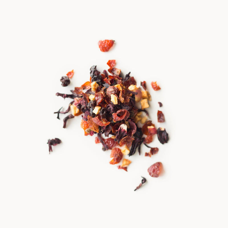 A pile of Hibiscus Berry dried fruit and nuts on a white background from Rishi Tea & Botanicals.