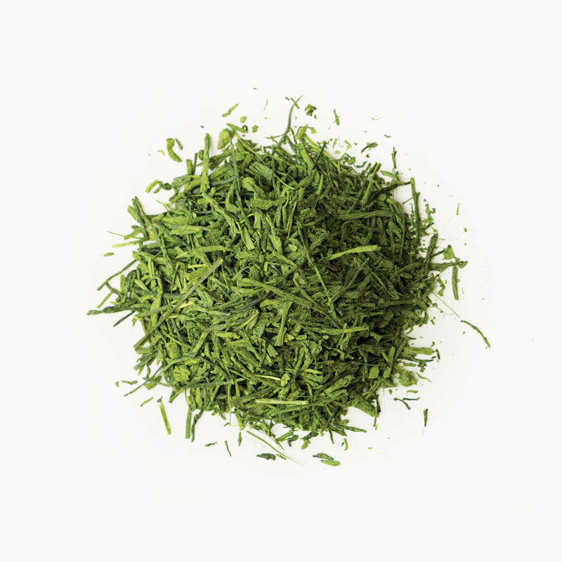 A pile of Matcha Gyokuro tea leaves on a white background, from Rishi Tea & Botanicals.