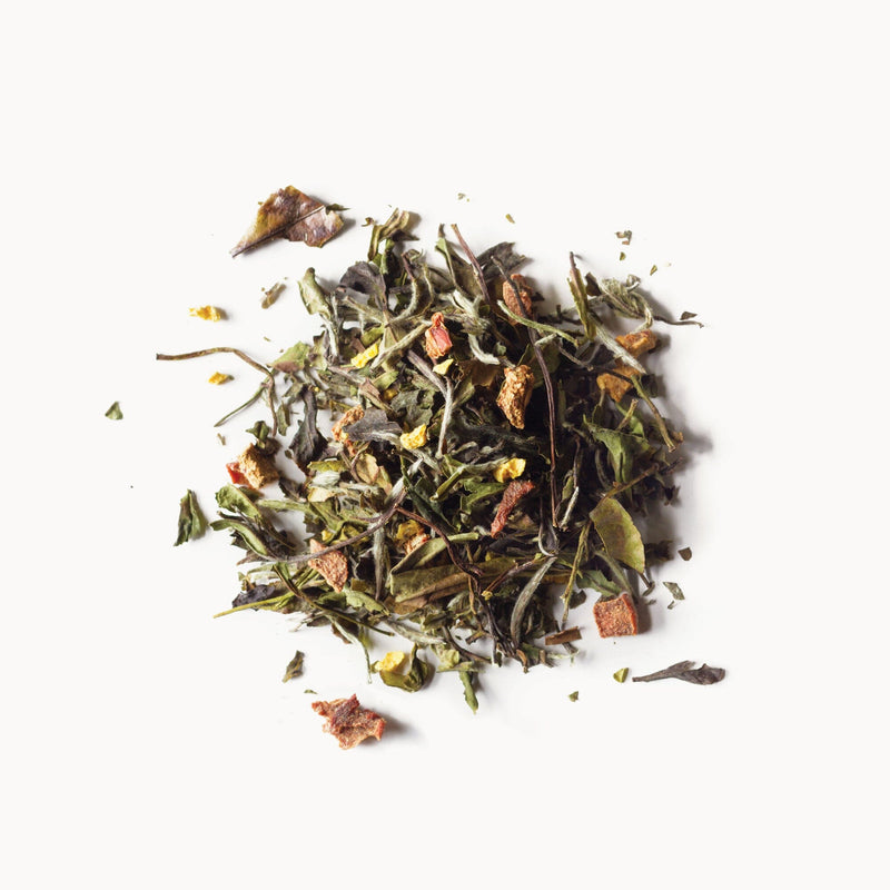 A pile of Peach Blossom green tea leaves on a white background by Rishi Tea & Botanicals.