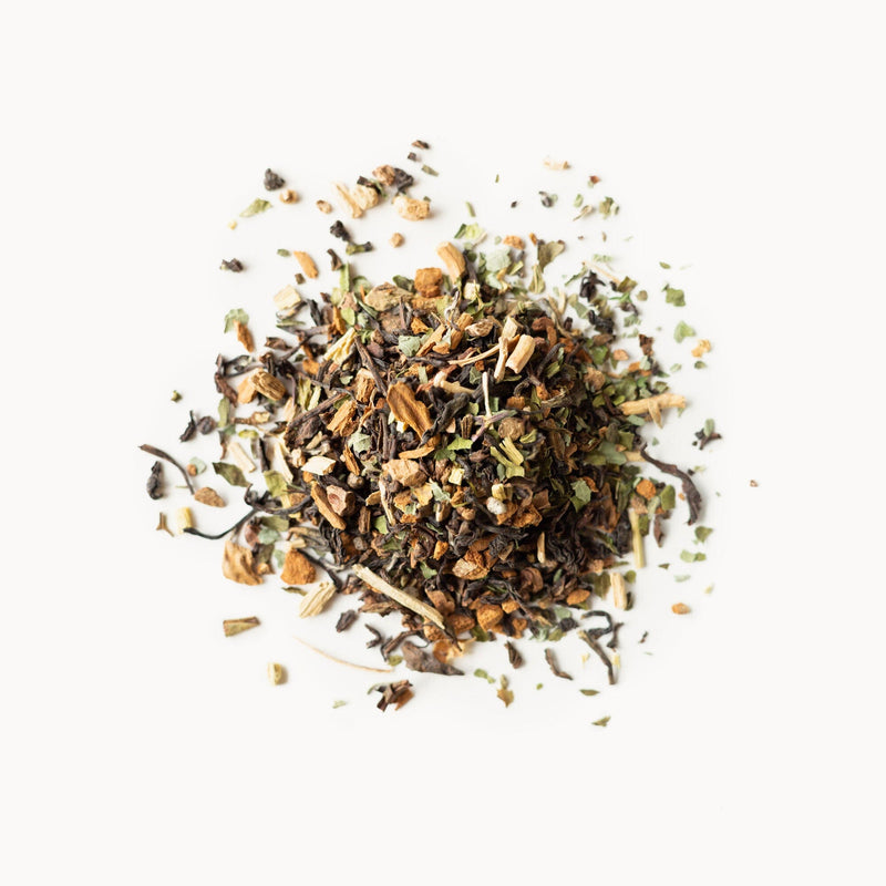 A pile of Tulsi Chai herbs and spices on a white background from Rishi Tea & Botanicals.