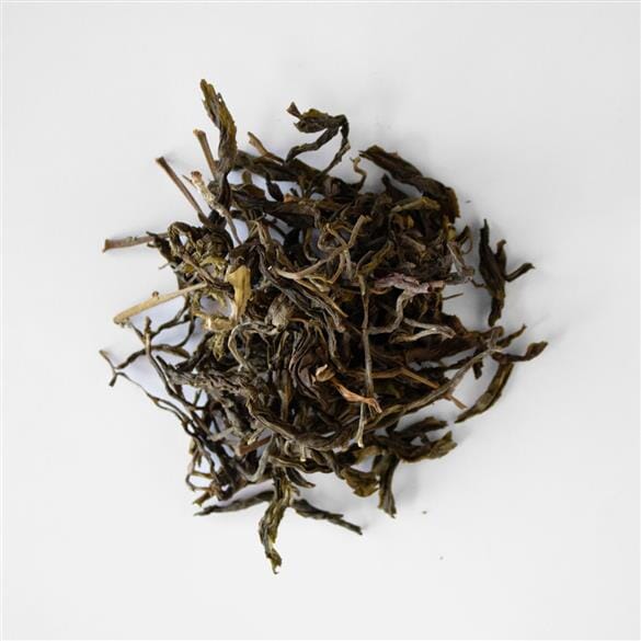 A pile of Doi Pu Muen Wild Tea Buds by Rishi Tea & Botanicals on a white surface.