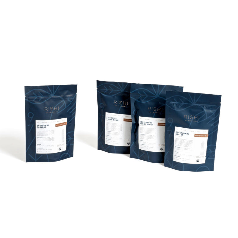 Description: Three bags of Berry Flight of Tea Bundle by Rishi Tea & Botanicals bundled together on a white background.