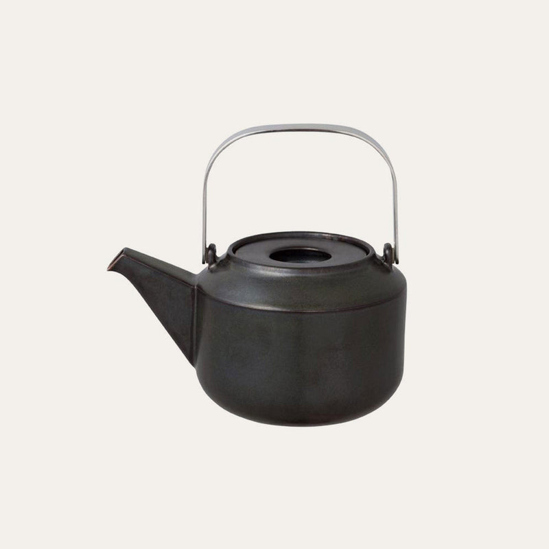 The Kinto Hasami Porcelain Teapot by Kinto USA, Inc, featuring a black metal design with a curved spout and a silver handle that showcases the elegance of Japanese craftsmanship, is showcased against a plain background.