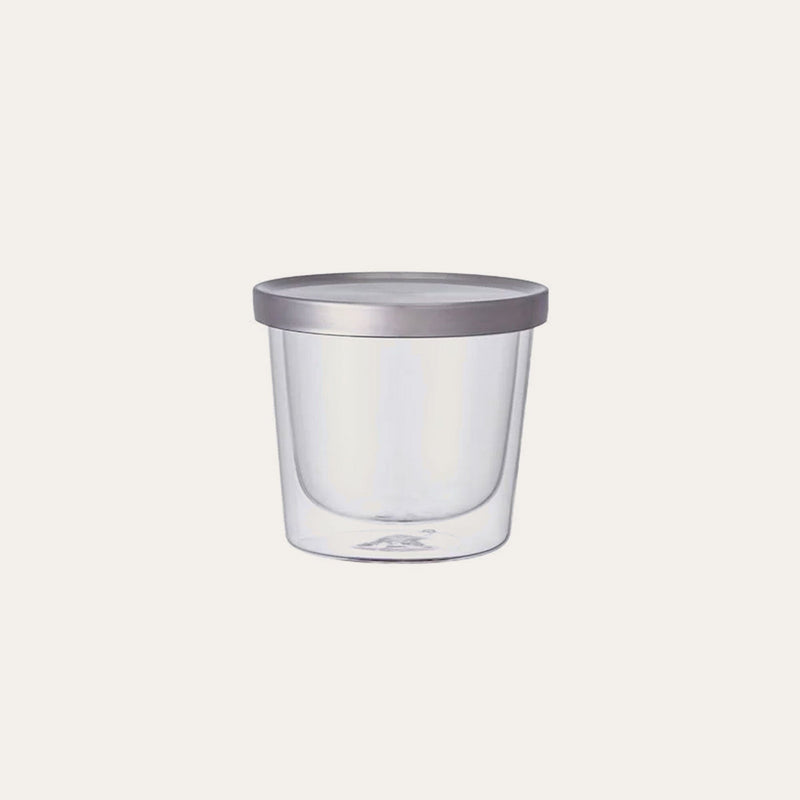 Introducing the Kinto Double Wall Glass Cup & Lid by Kinto USA, Inc—a clear, round heat-resistant container with a sleek gray lid, elegantly showcased against a plain, light background.