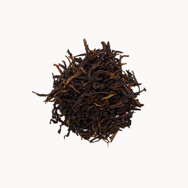 A pile of loose-leaf black tea from Rishi Tea & Botanicals, reminiscent of the prized Phoenix Dancong Mi Lan Xiang from Phoenix Mountain, sits against a plain white background.