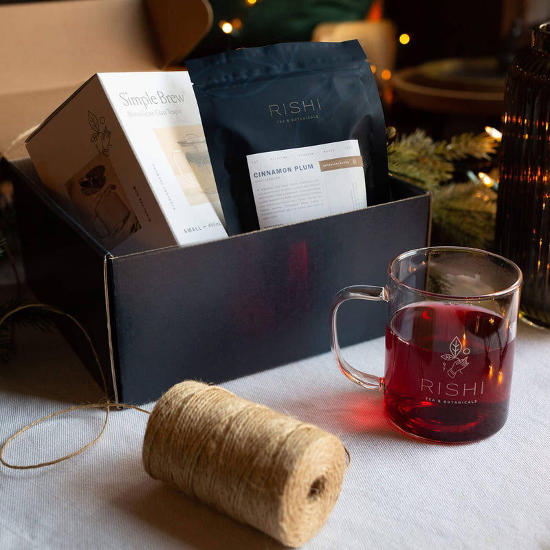 Monthly deliveries of curated Rishi Tea Club teas to explore, with a cup of Rishi Tea & Botanicals next to the box.