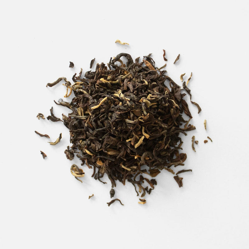 A pile of Darjeeling Second Flush Shree Dwarika EX2 tea by Rishi Tea & Botanicals on a white background.