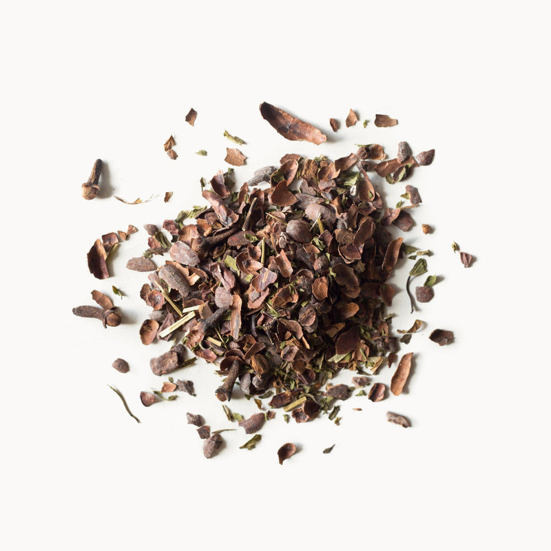 A pile of Cocoa Mint tea leaves on a white background from Rishi Tea & Botanicals.