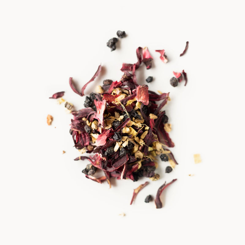 A pile of Elderberry Healer flowers and berries on a white surface, from Rishi Tea & Botanicals.