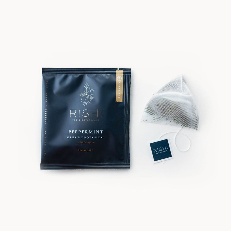 A bag of Peppermint tea with a Rishi Tea & Botanicals tea bag next to it.