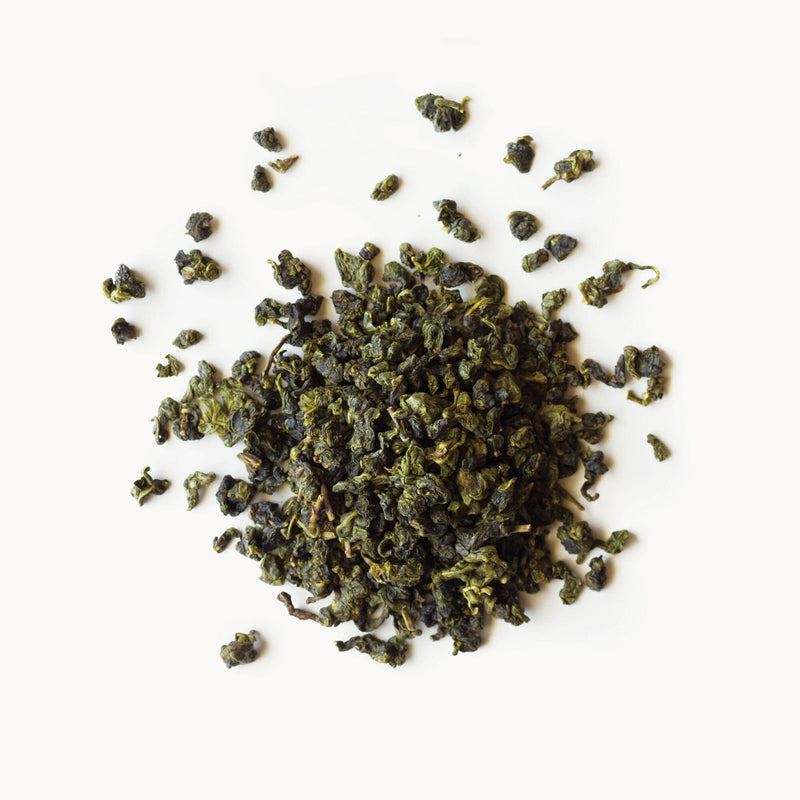 A pile of Four Seasons Spring green tea from Rishi Tea & Botanicals on a white background.