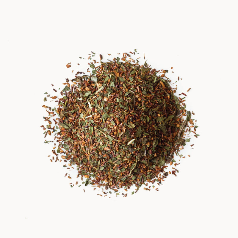 A pile of Peppermint Rooibos - Organic from Rishi Tea & Botanicals on a white background.
