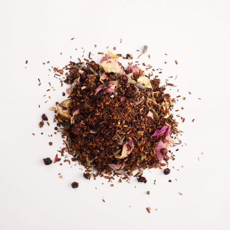 A pile of Bergamot Rose herbs and flowers on a white background by Rishi Tea & Botanicals.