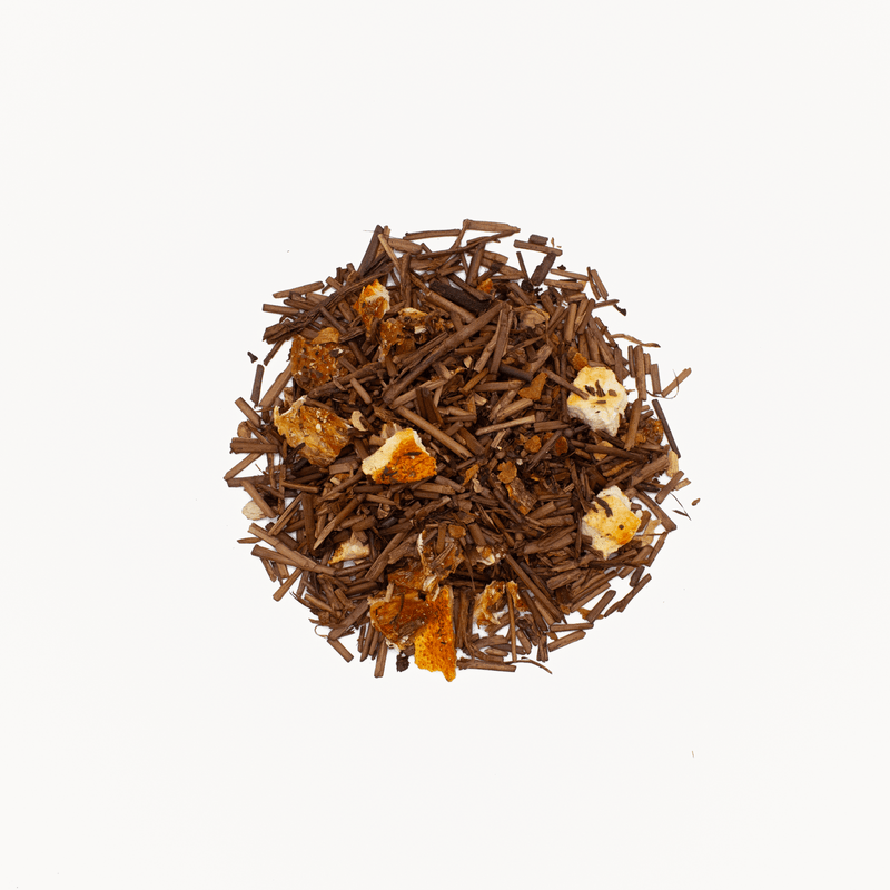 A pile of loose Houjicha Cinnamon Orange tea leaves by Rishi Tea & Botanicals, infused with zesty orange peels, rests on a white background.