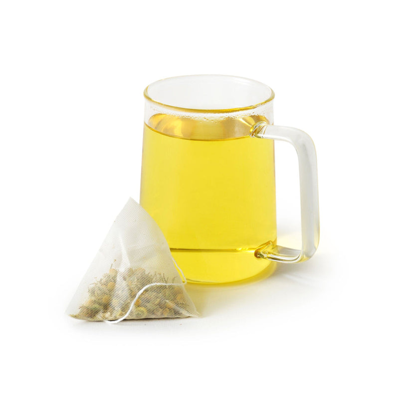 A cup of tea with a Golden Chamomile Blossoms Double-Dose tea bag next to it, infused with Croatian chamomile blossoms for a sweet flavor from Rishi Tea & Botanicals.