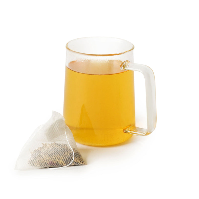 A cup of Valerian Dream Double-Dose tea with a Rishi Tea & Botanicals nervine tonic herb tea bag next to it.