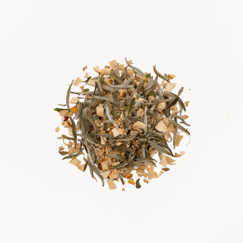 A blend of Rishi Tea & Botanicals' Quince Ginger, featuring Silver Needles white tea leaves and aromatic orange peel, is elegantly arranged on a simple white backdrop.