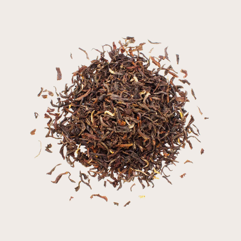 A pile of Darjeeling Second Flush Lingia DJ52 loose leaf tea from Rishi Tea & Botanicals, known for its exquisite quality, seen from above on a plain light background.