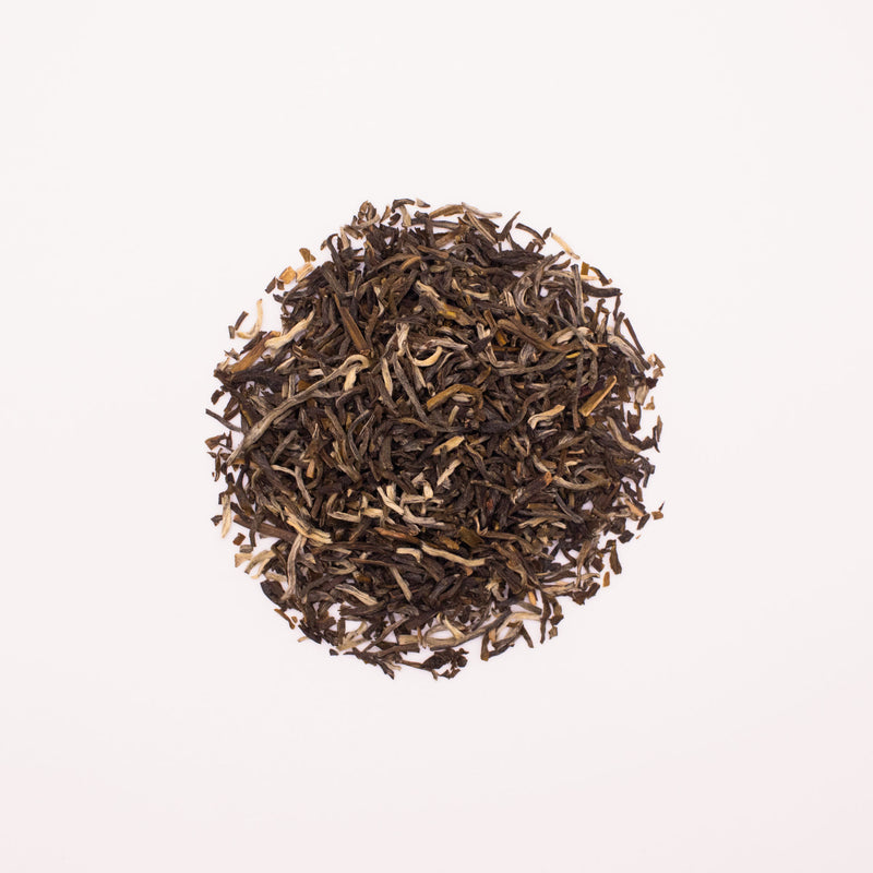 A pile of Jasmine Yin Hao loose-leaf tea from Rishi Tea & Botanicals, reminiscent of the finest 2024 harvest, is elegantly arranged in a circular formation on a white background.