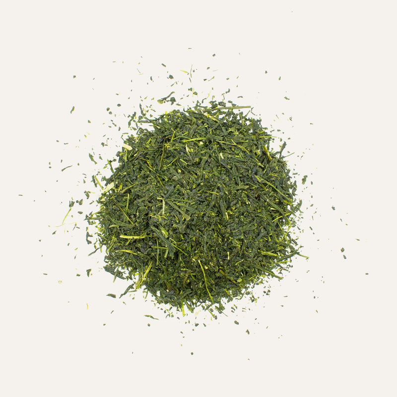 A pile of loose Shincha Yutaka Midori green tea leaves from Rishi Tea & Botanicals against a plain white background.