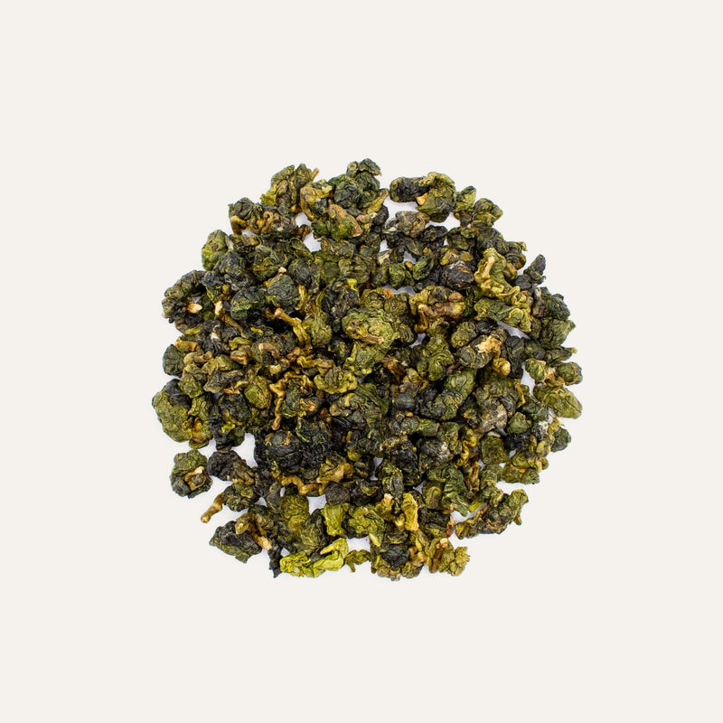 A refreshing pile of Shan Lin Xi Oolong Winter Harvest on a pristine white background, perfect for cold brewing methods, brought to you by Rishi Tea & Botanicals.