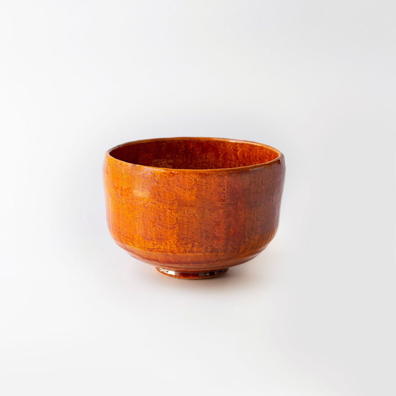 A small orange Red Shoraku matcha bowl on a white background, by Chato Co., Ltd.