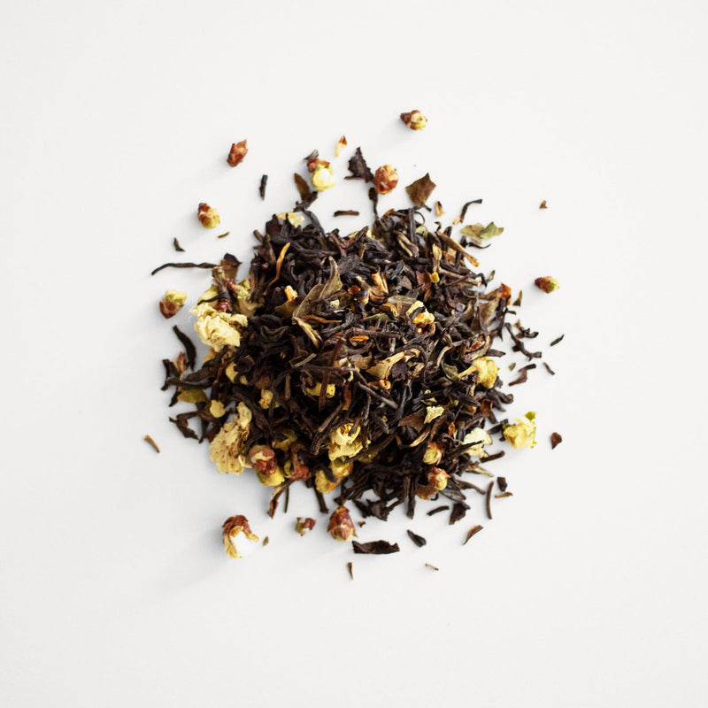 A pile of Plum Blossom Black Tea by Rishi Tea & Botanicals on a white surface.