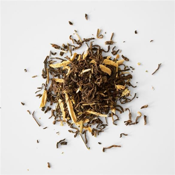 A pile of Anise Hyssop Pu’er tea leaves on a white surface, by Rishi Tea & Botanicals.