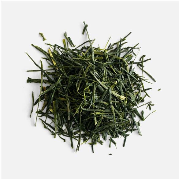A pile of Hon Yama Okouchi Sencha green tea leaves on a white background.