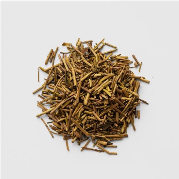 A pile of Houjicha Cardamom tea leaves on a white background. (Brand: Rishi Tea & Botanicals)