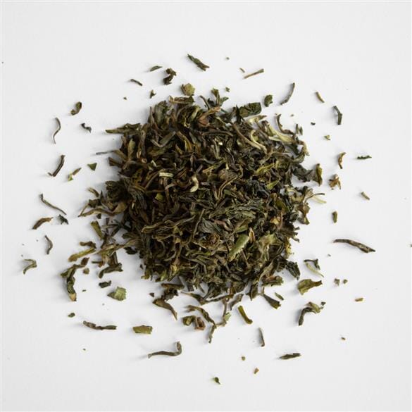 A pile of Darjeeling First Flush Tumsong DJ2 green tea from Rishi Tea & Botanicals on a white surface.