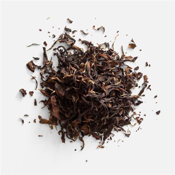 A pile of Yunnan Dong Fang Hong tea leaves on a white background, from Rishi Tea & Botanicals.