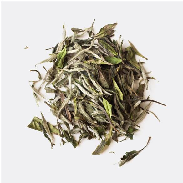A pile of White Peony King tea on a white background from Rishi Tea & Botanicals.