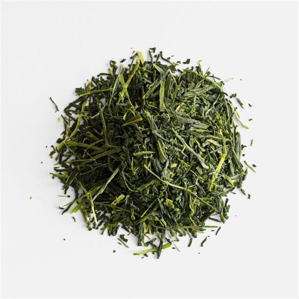 A pile of Nishi Shincha Okumidori green tea on a white background by Rishi Tea & Botanicals.