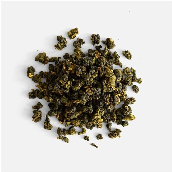 A pile of Shan Lin Xi Gao Shan Cha South Face green tea on a white background by Rishi Tea & Botanicals.