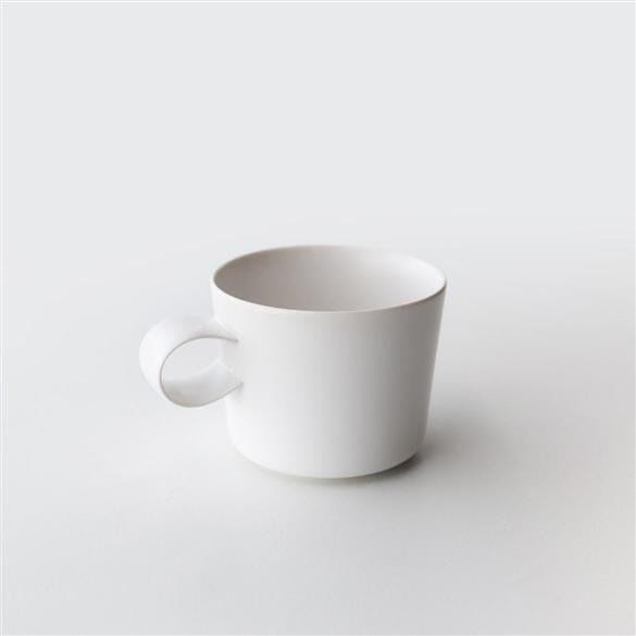 A Yumiko Iihoshi White Cup on a white surface by Rishi Tea & Botanicals.