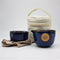 A Brewing Nest Ceramic Travel Teapot tea set with a Rishi Tea & Botanicals bag next to it.